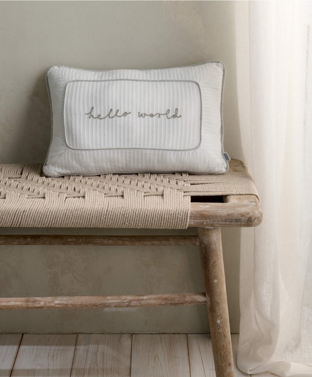 White and grey welcome cushion with quilted border and cursive 'world' print