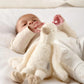 Cream duckling plush toy, soft arms and feet, lying on blanket