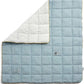 Blue cotbed quilt with white side, quilted squares and small embroidered sheep motifs