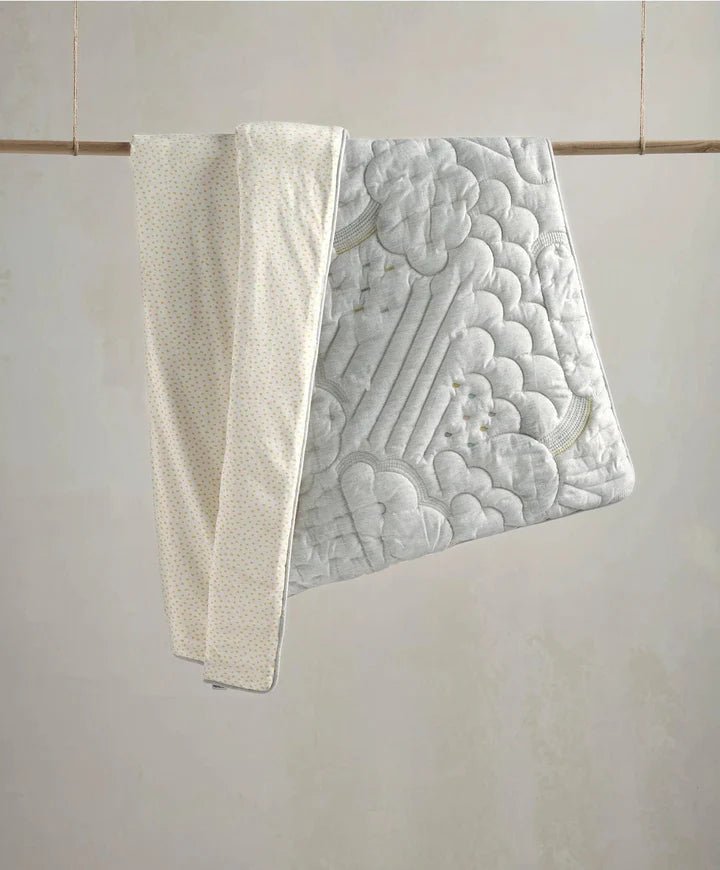 Cotbed quilt with raised cloud quilt pattern in light gray