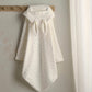 White hooded towel with small dot pattern and gathered neck, hanging