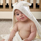 White hooded towel with small dot pattern, baby wrapped in front view