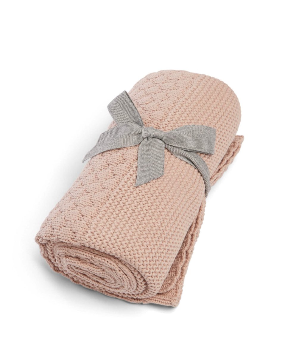 Seedling knitted blanket in dusty pink, folded with gray bow ribbon at center
