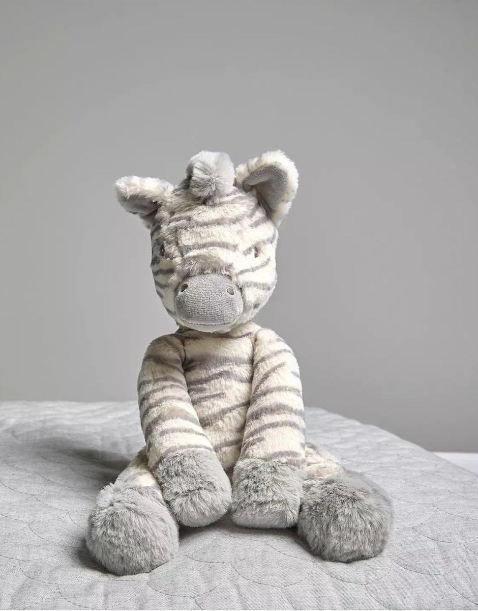Soft toy zebra plush with gray-and-white stripes, sitting upright on fabric
