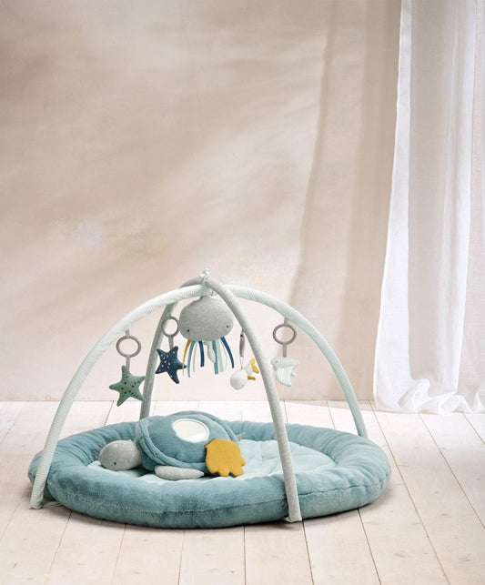 Blue round baby play mat with arched toy bar and sea-themed plush sea creatures