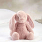 Light pink plush bunny soft toy, side view with floppy ears and small nose.