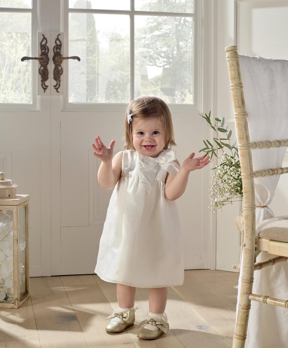 White organza bow dress, sleeveless with bow shoulder detail and ruffled neckline