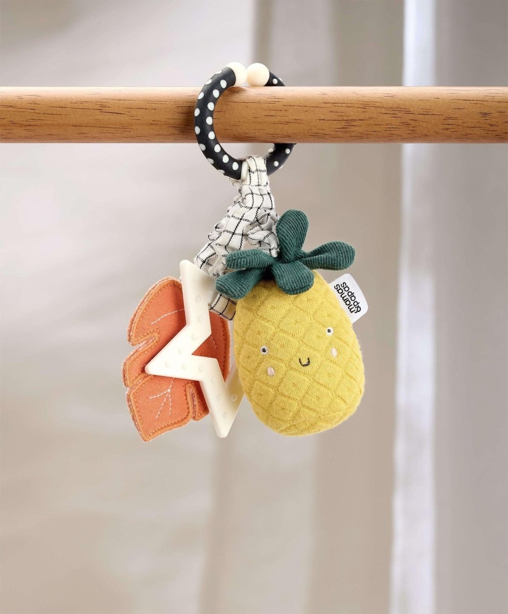 Pineapple teething toy hanging on bar: plush pineapple, fabric star, orange leaves on ring