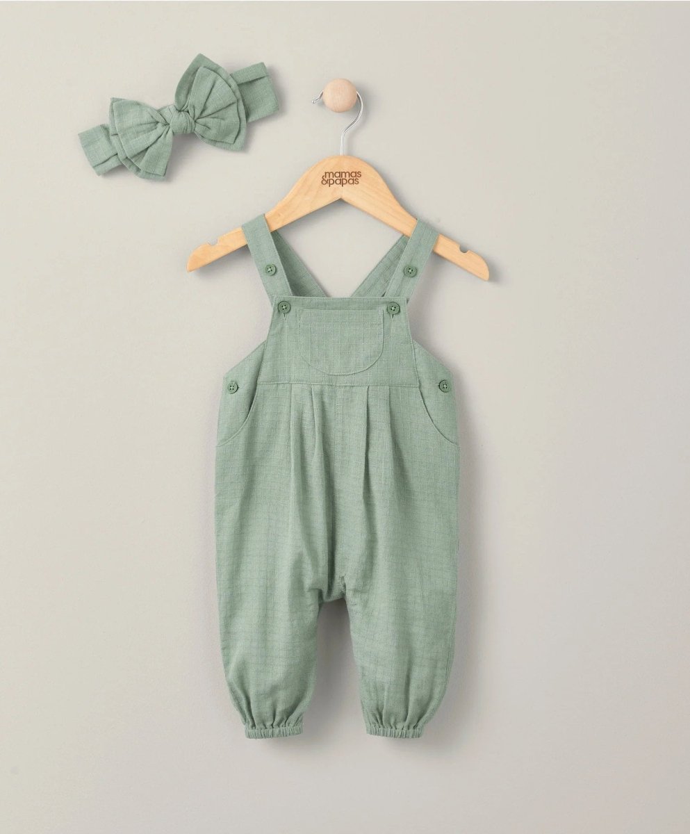 Green woven dungarees with bow headband, front straps and button pockets