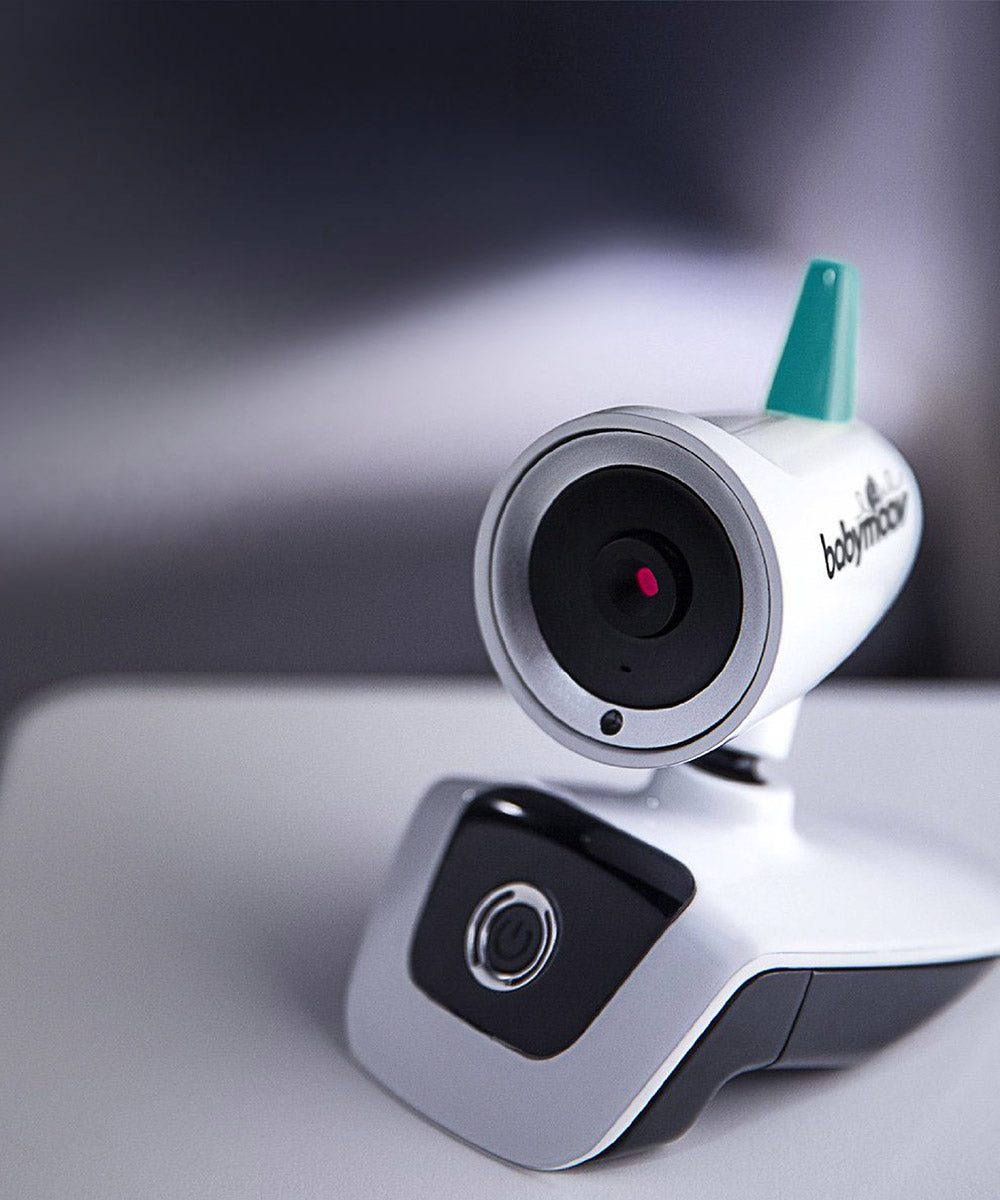 Close-up of white video baby monitor camera with teal antenna and lens