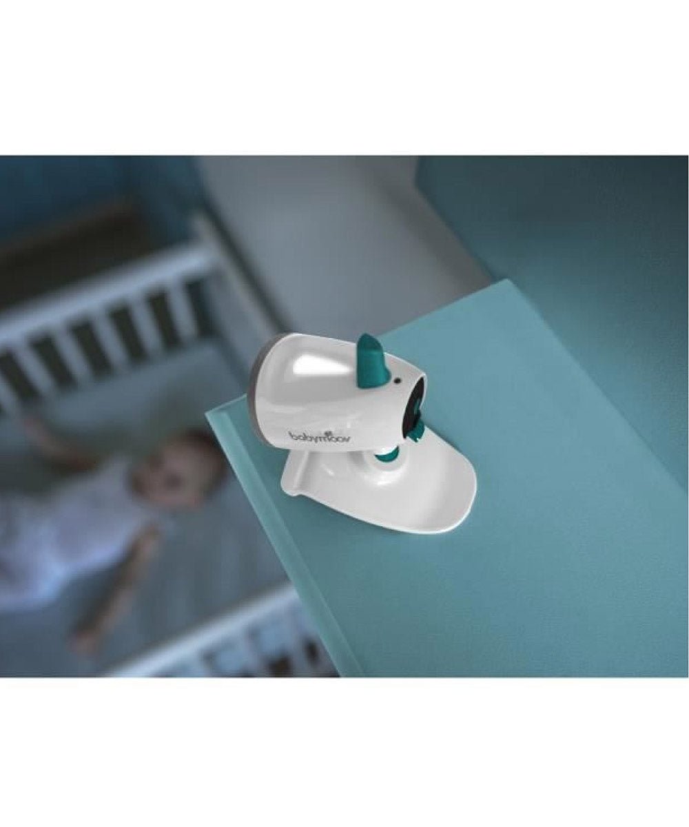 Video baby monitor camera mounted on a crib surface with teal antenna