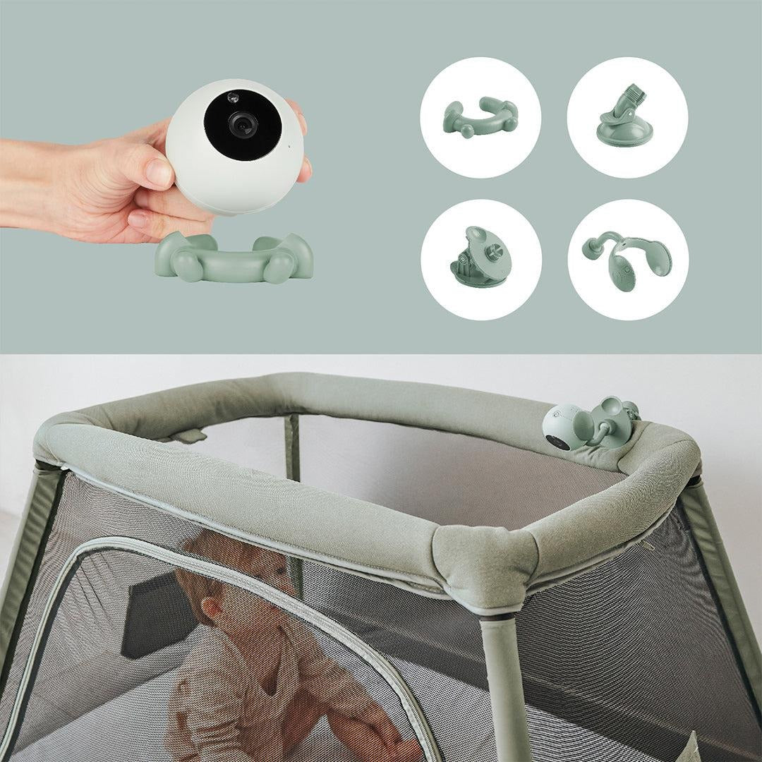 Portable baby monitor camera and green mounting accessories in hand