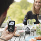 Portable baby monitor in a hand with small screen and teal antenna