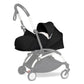 Black newborn stroller seat pack with canopy and harness, front view