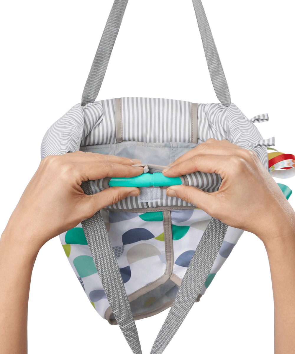 Door jumper harness adjustment: hands securing teal buckle on striped inner panel