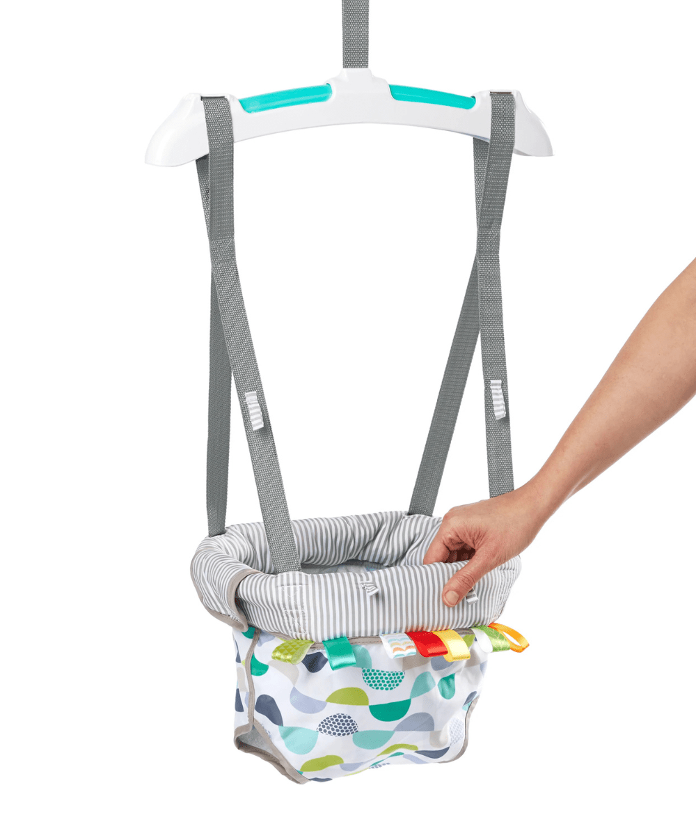 Door jumper harness close-up: gray webbing straps over striped seat and patterned pocket