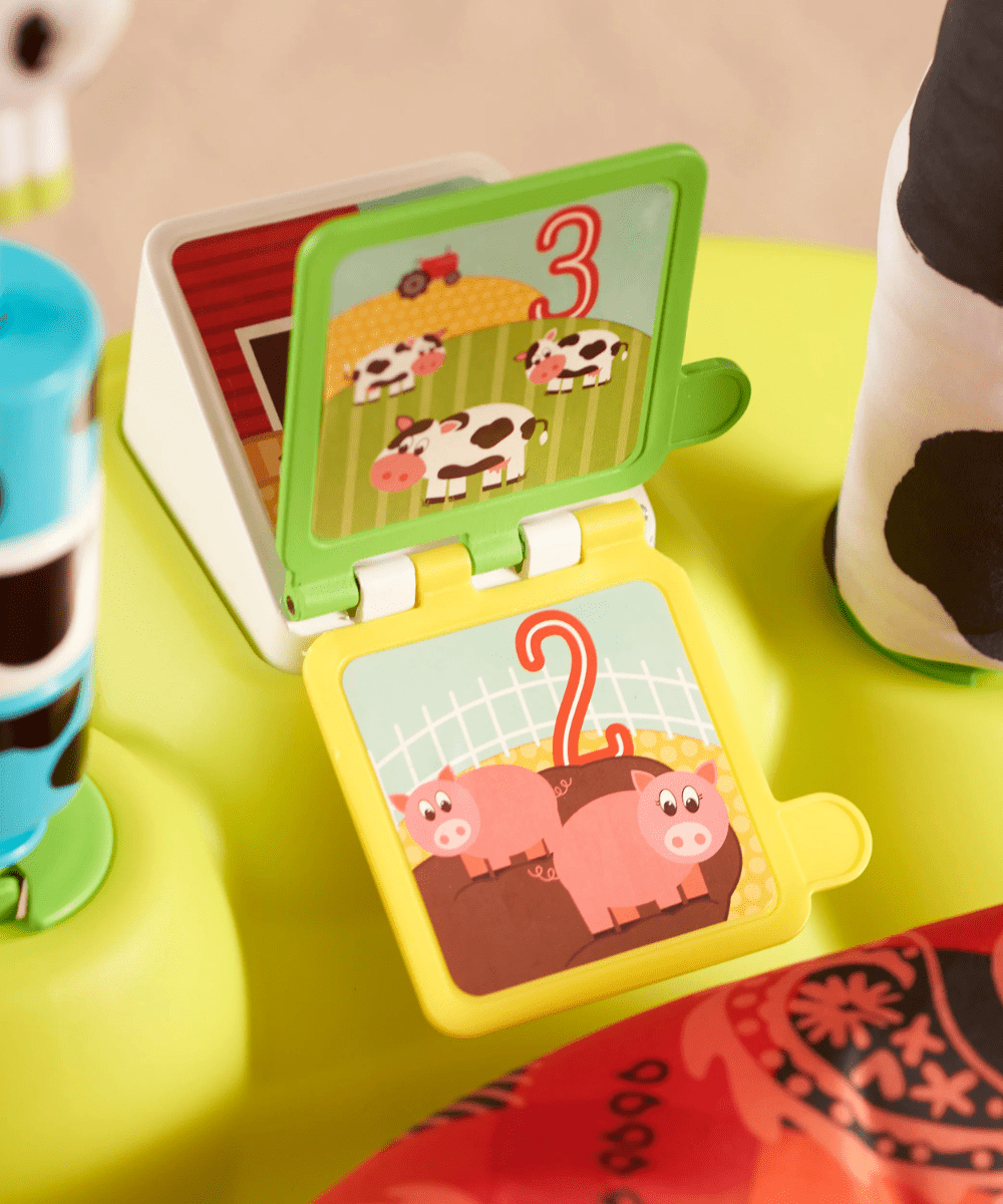 Open book play panel with farm animal pages on yellow-green saucer