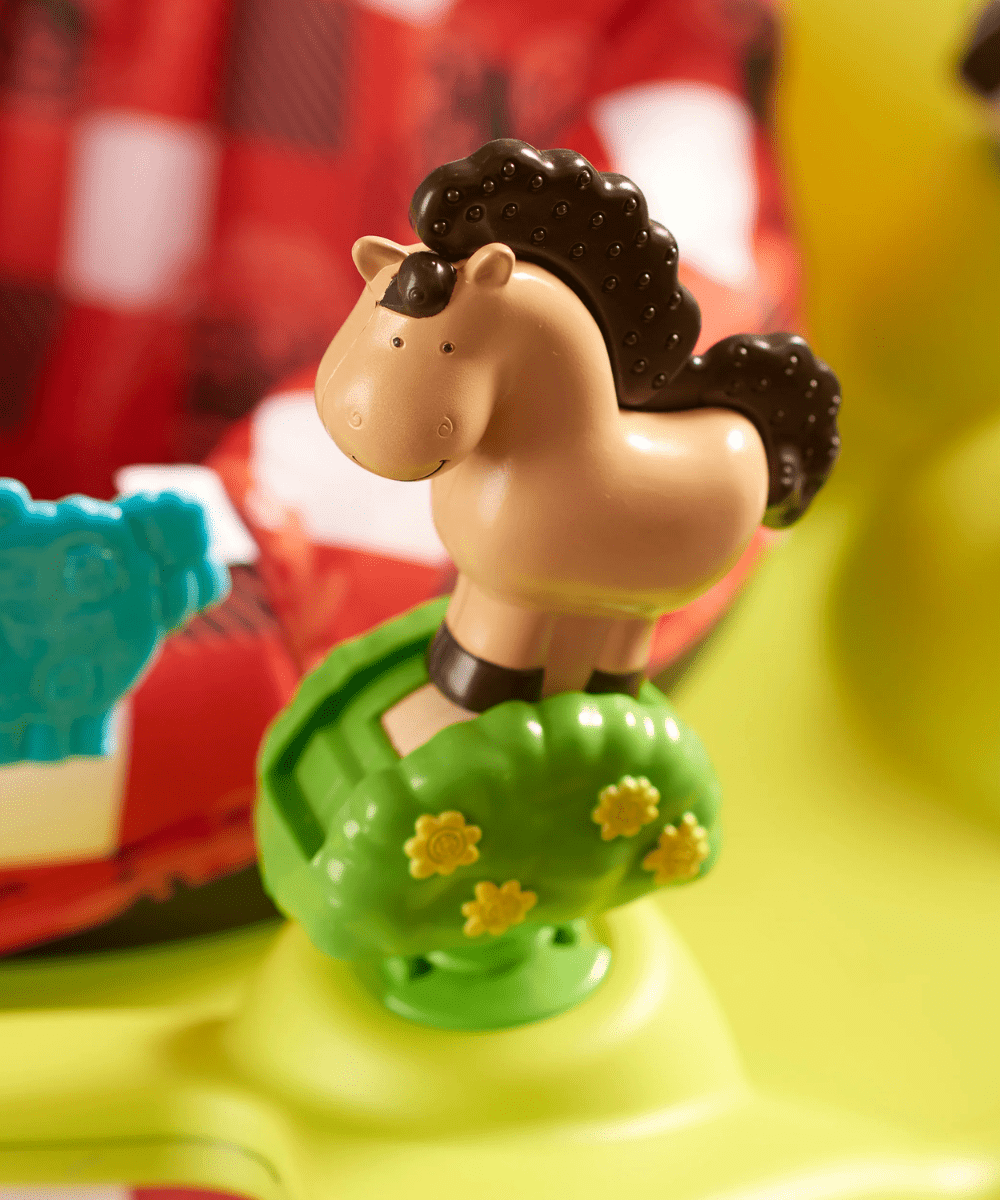 Farm animal figure atop green toy base on activity saucer