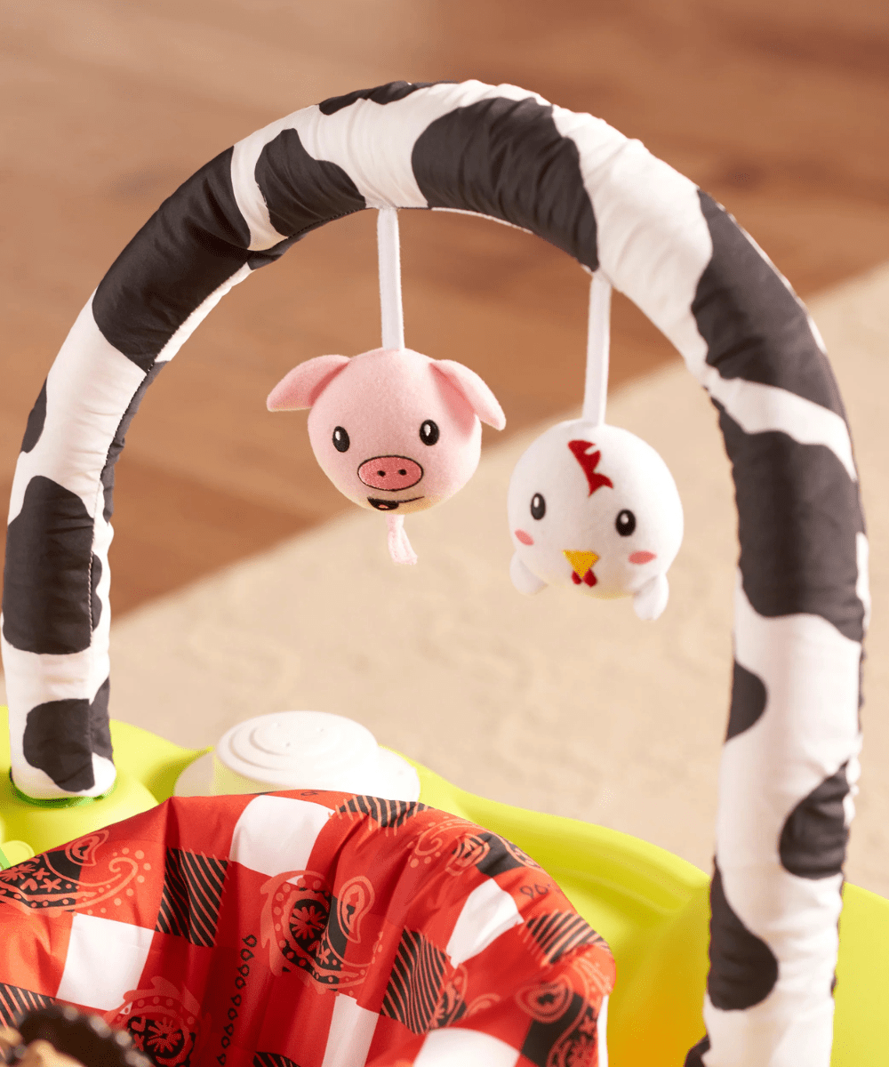 Farm-themed hanging plush toys on black-and-white arch