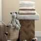 Stack of folded sheets with small rainbow and cloud designs in light colors