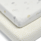 White baby sheet with small cloud and rainbow prints, neatly folded at corner