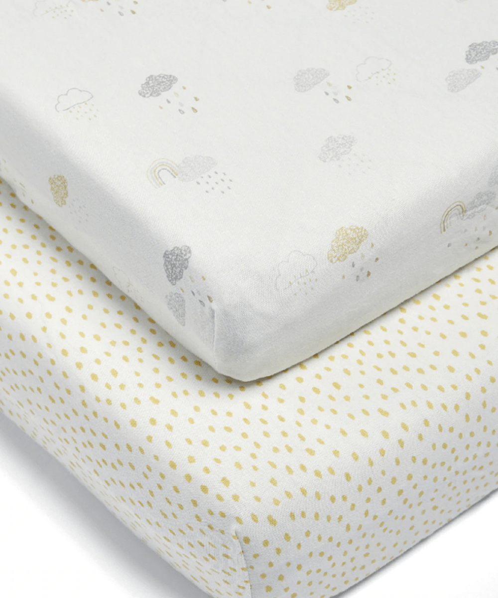 White baby sheet with small cloud and rainbow prints, neatly folded at corner