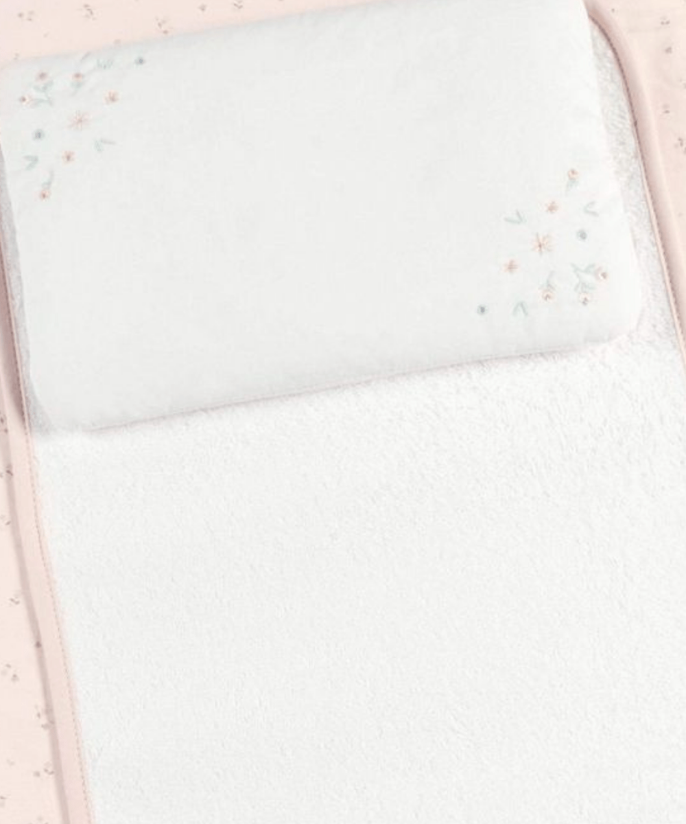White padded changing mat with small pastel floral stitching on top panel